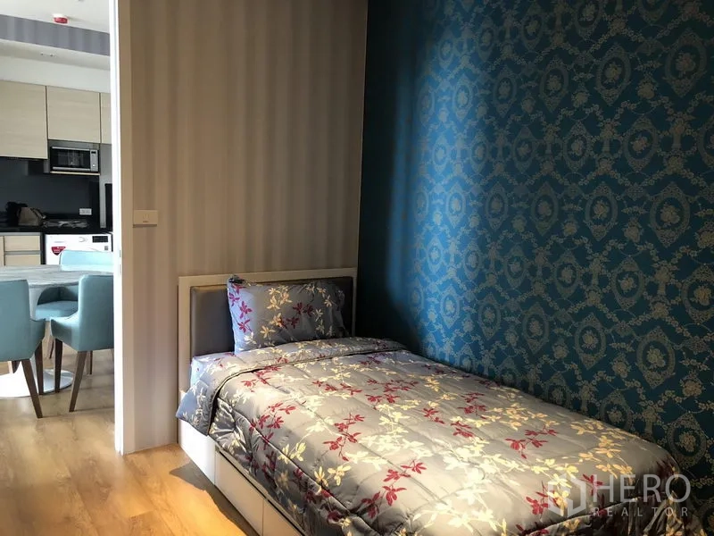 Condominium for rent in Khlong Toei, Bangkok - Second bedroom with single bed and blue patterned accent wall.