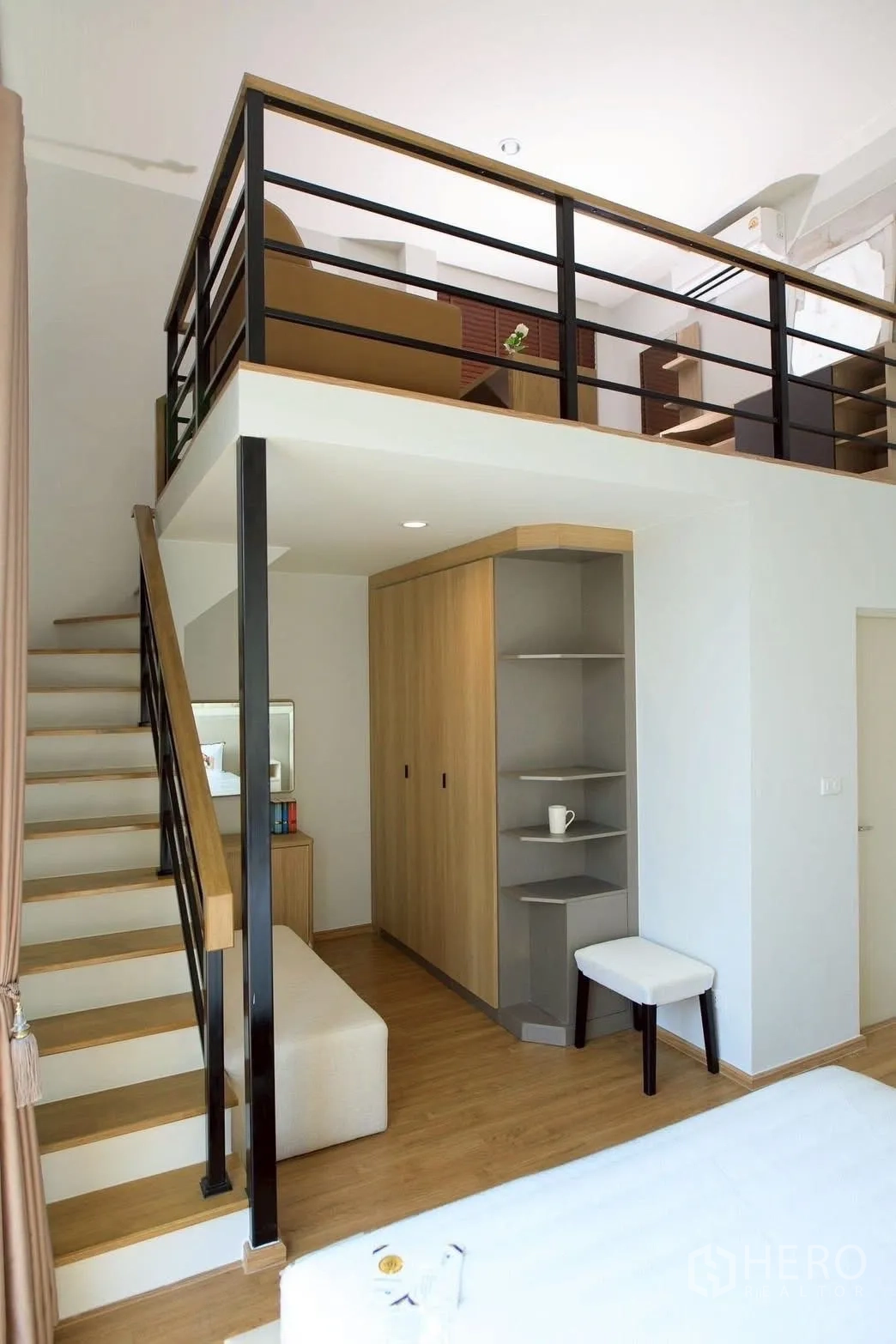 Townhouse for rent or sale in Bang Phli, Samut Prakan - Bedroom staircase leading to a mezzanine lounge above built-in wardrobe and shelving.