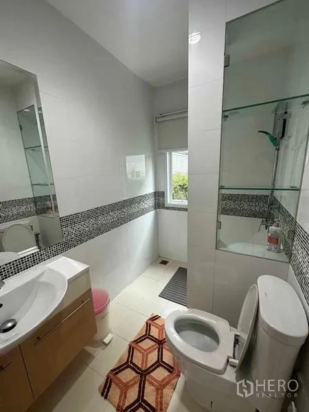 独立式住宅 出售在Saphan Sung, Bangkok - 紧凑浴室，带玻璃淋浴间、台盆与白色瓷砖。
