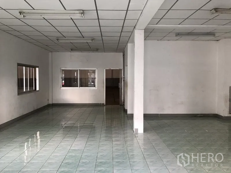 工厂 出租在Pathum Thani - 宽敞的办公室或展厅，荧光灯照明与瓷砖地面。