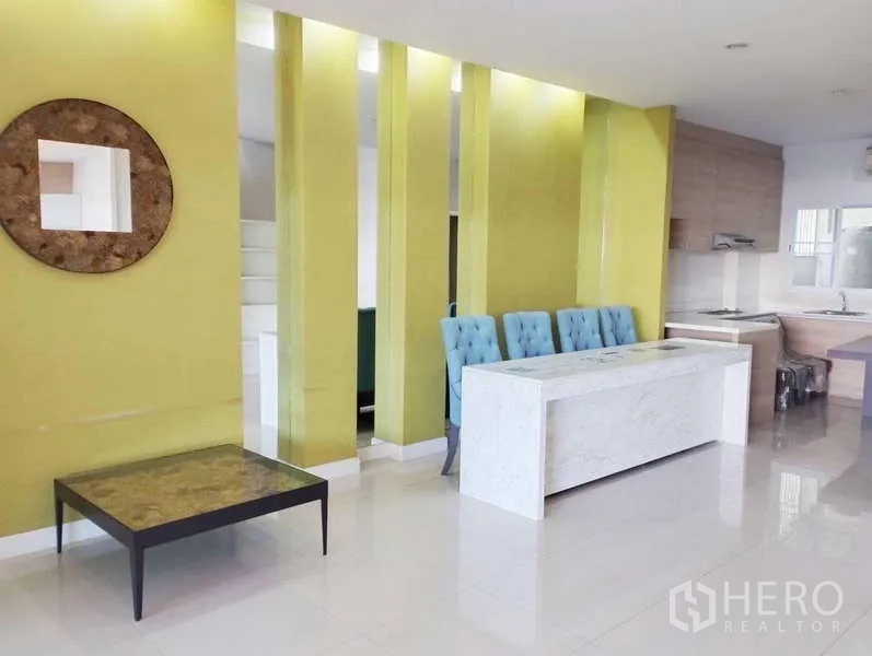 ทาวน์เฮาส์ ให้เช่าในSaphan Sung, Bangkok - พื้นที่นั่งเล่นและครัวแบบเปิด ผนังไฮไลต์สีเขียว เคาน์เตอร์หิน และพื้นเงา