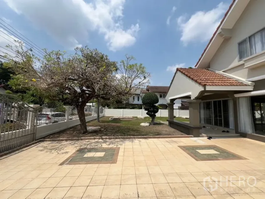 独立式住宅 出售在Mueang Pathum Thani, Pathum Thani - 前庭铺砖车道，成树与带顶门廊。