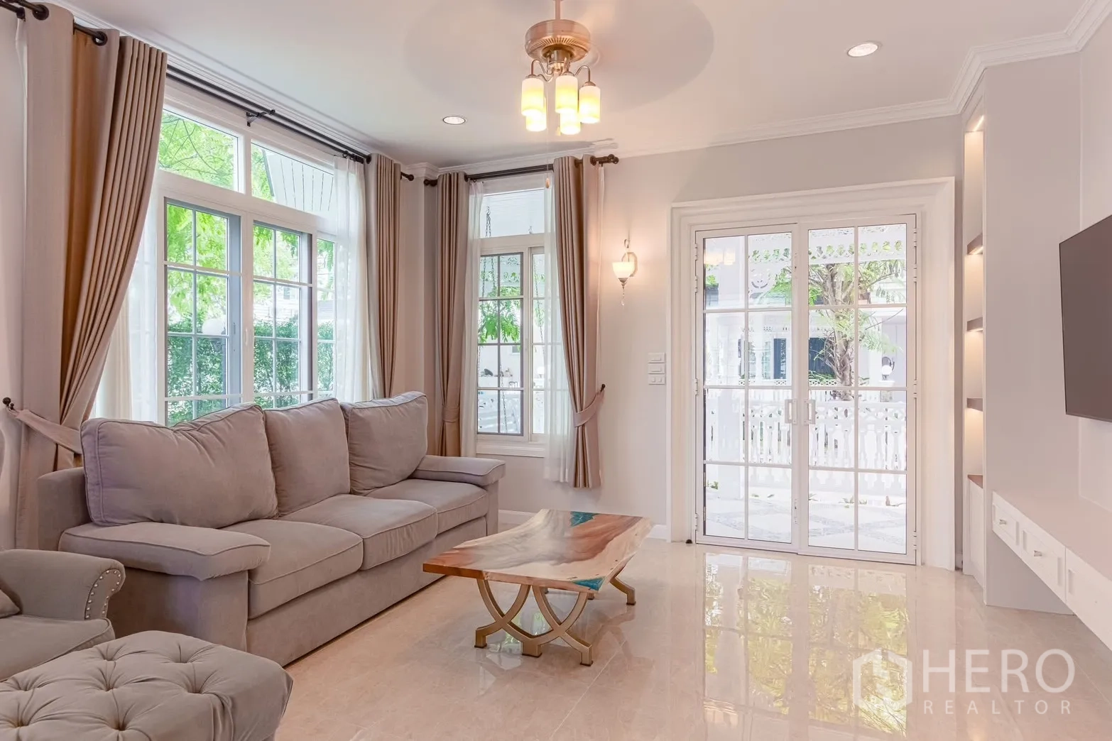 บ้านเดี่ยว for rent in Bang Na, Bangkok - ห้องนั่งเล่นรับแสงธรรมชาติ โซฟาสีเทา หน้าต่างบานใหญ่พร้อมม่าน และประตูบานฝรั่งเศส