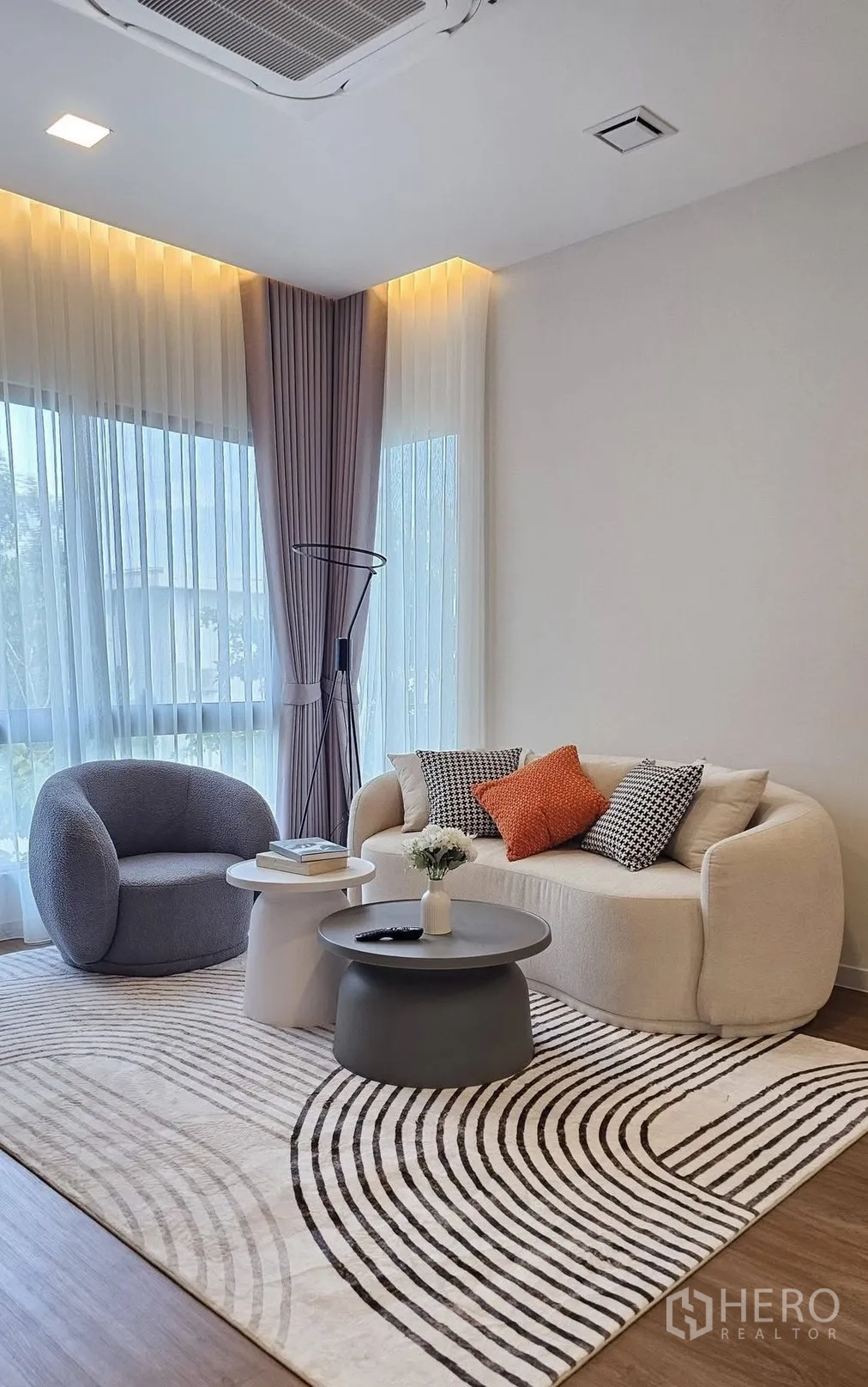 独栋房屋 for rent in Bang Phli, Samut Prakan - 起居区配弧形沙发、单椅、叠放式圆几与图案地毯。