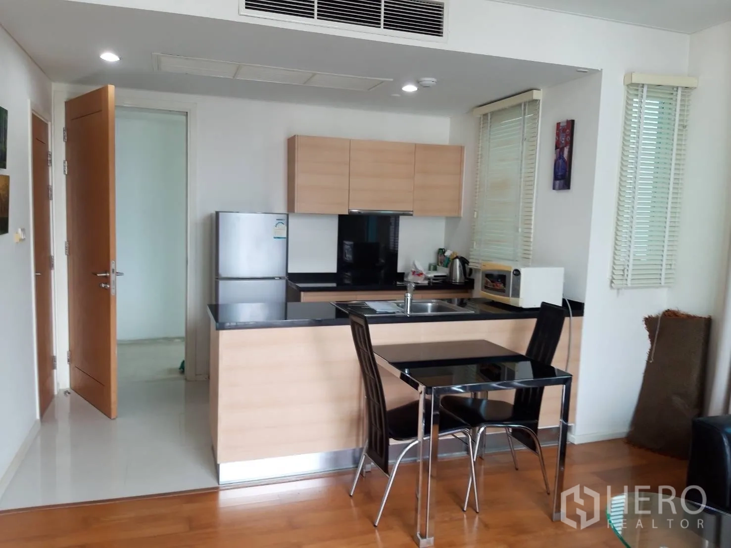 คอนโด ให้เช่าในWatthana, Bangkok - ครัวพร้อมเคาน์เตอร์หินสีดำและชุดโต๊ะทานข้าวสองที่นั่ง