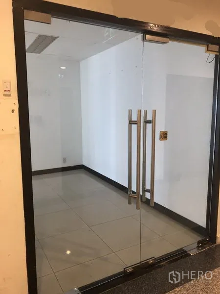 办公空间 出租在Watthana, Bangkok - 玻璃双开门的办公室入口，瓷砖地面，空置空间