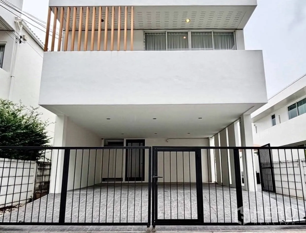 Detached House for rent in Saphan Sung, Bangkok - Modern white detached house facade with gated covered carport.