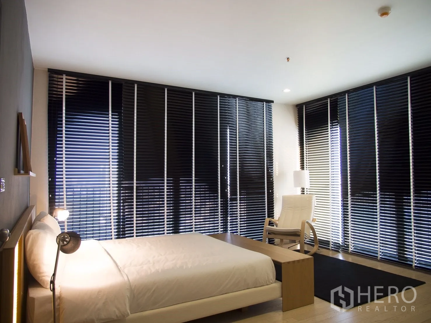 Condominium for rent in Watthana, Bangkok - Corner bedroom with wraparound windows, blackout blinds and reading chair.