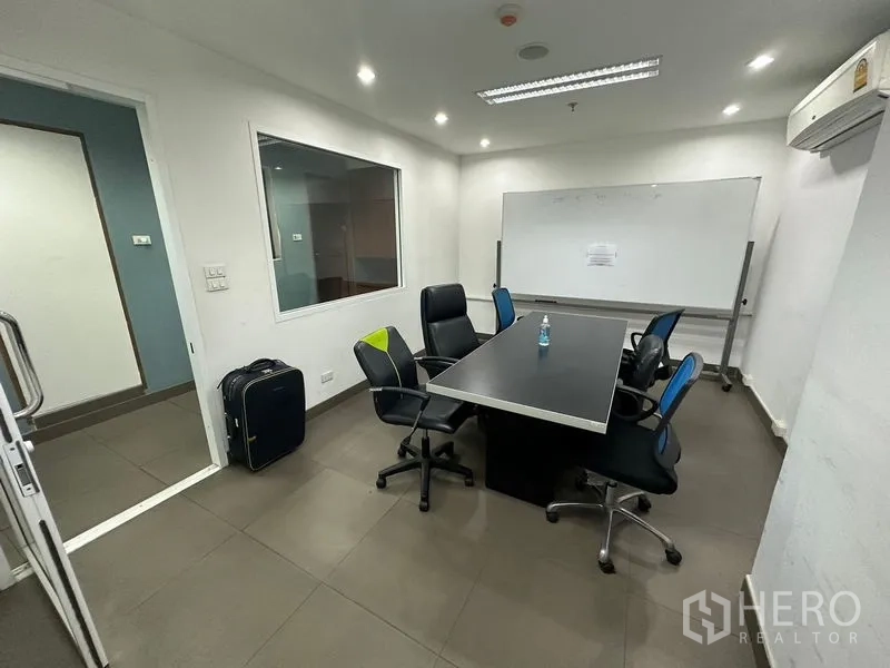 สำนักงาน ให้เช่าหรือขาย - ห้องประชุมขนาดเล็กมีกระดานไวท์บอร์ด โต๊ะสี่เหลี่ยม และเก้าอี้ล้อ
