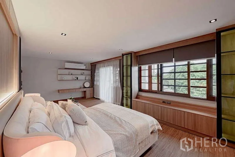 Detached House for rent or sale in Phra Khanong, Bangkok - Bright bedroom with large windows, built-in desk, and cabinetry overlooking greenery.