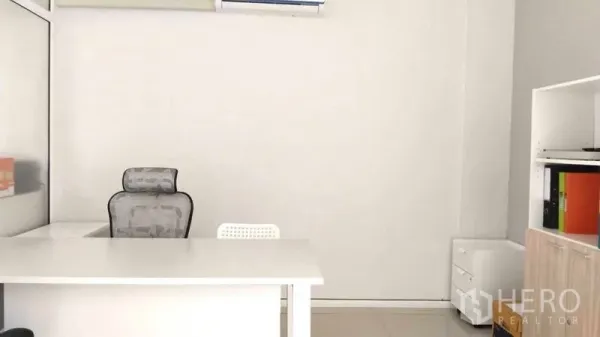 Home Office for rent - Private manager’s office with white desk, chair and storage cabinets.