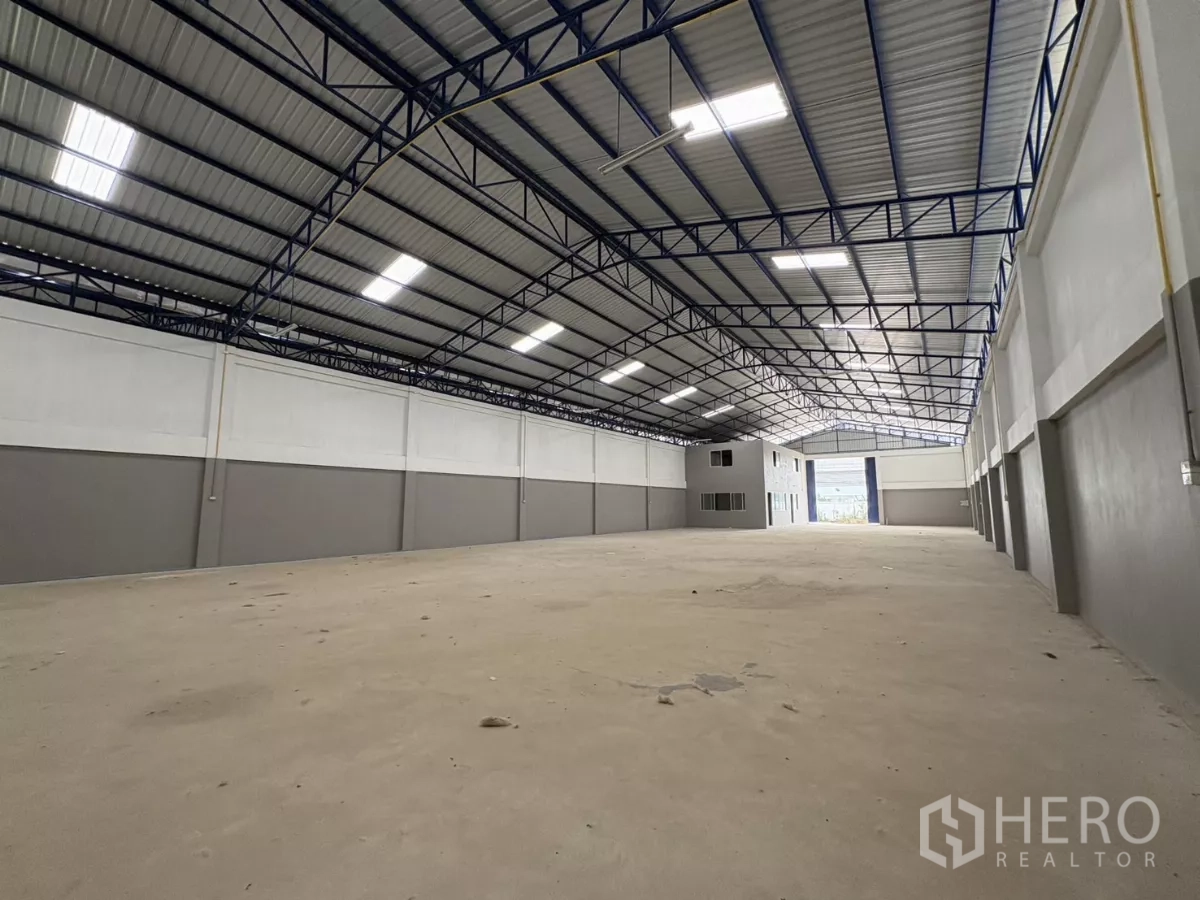Warehouse for rent in Mueang Samut Prakan, Samut Prakan - Wide production or storage area with steel roof trusses and ventilation panels.