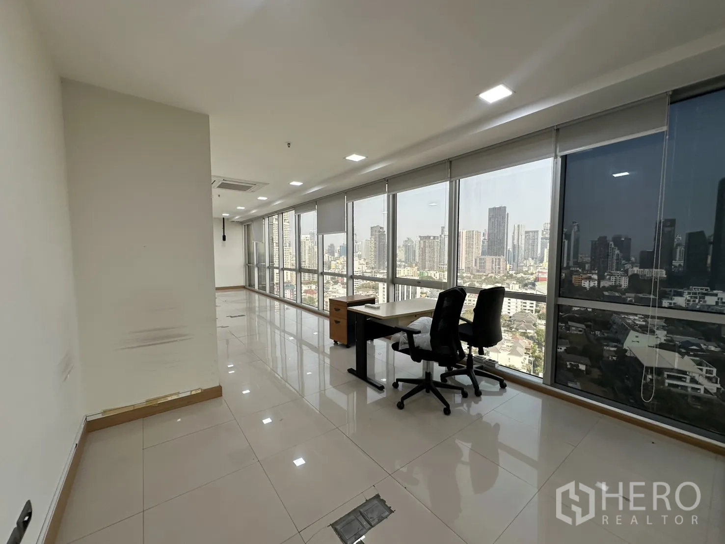 Office Space for rent - Work zone with two chairs at the windowed facade facing the skyline.