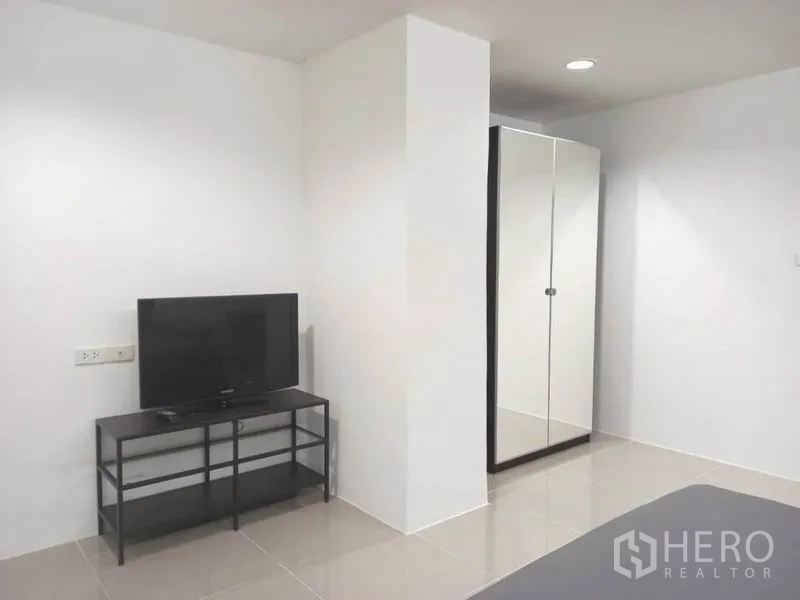 公寓 出租在Khlong Toei, Bangkok - 卧室内电视与电视柜，对面为整面镜面衣柜。
