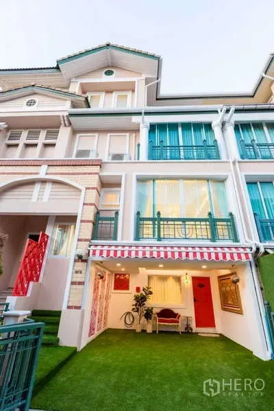 ทาวน์เฮาส์ ให้เช่าในLat Phrao, Bangkok - ภายนอกทาวน์เฮ้าส์ กันสาดลายทาง โรงจอดรถหน้าบ้าน และสนามหญ้าเทียม