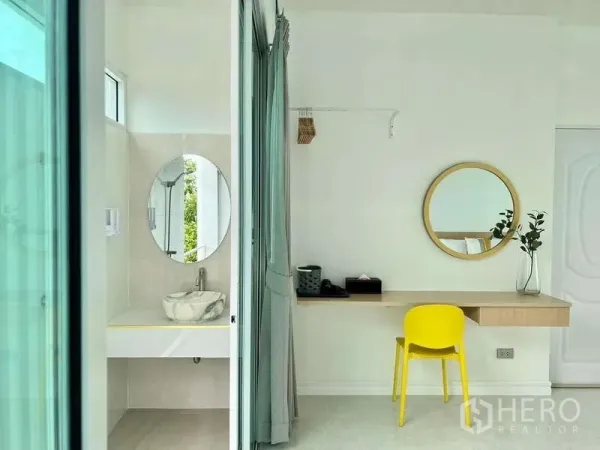 Detached House for rent in Lat Krabang, Bangkok - Work desk with round mirror beside an ensuite vanity separated by a sliding curtain.
