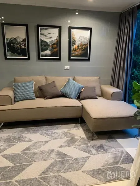 带办公室的家 出租在Saphan Sung, Bangkok - 温馨客厅，米色转角沙发、几何地毯与墙面装饰画。