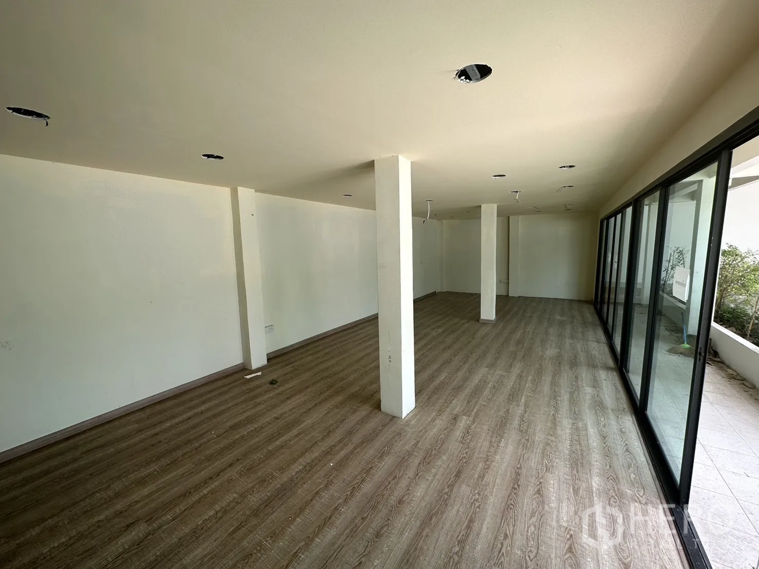 Warehouse for rent in Suan Luang, Bangkok - Long open-plan office with wood-look flooring and sliding glass panels.