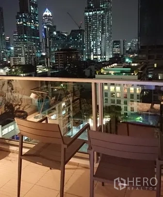 公寓 出租在Pathum Wan, Bangkok - 私家阳台配两把椅子，俯瞰曼谷夜间城市天际线。