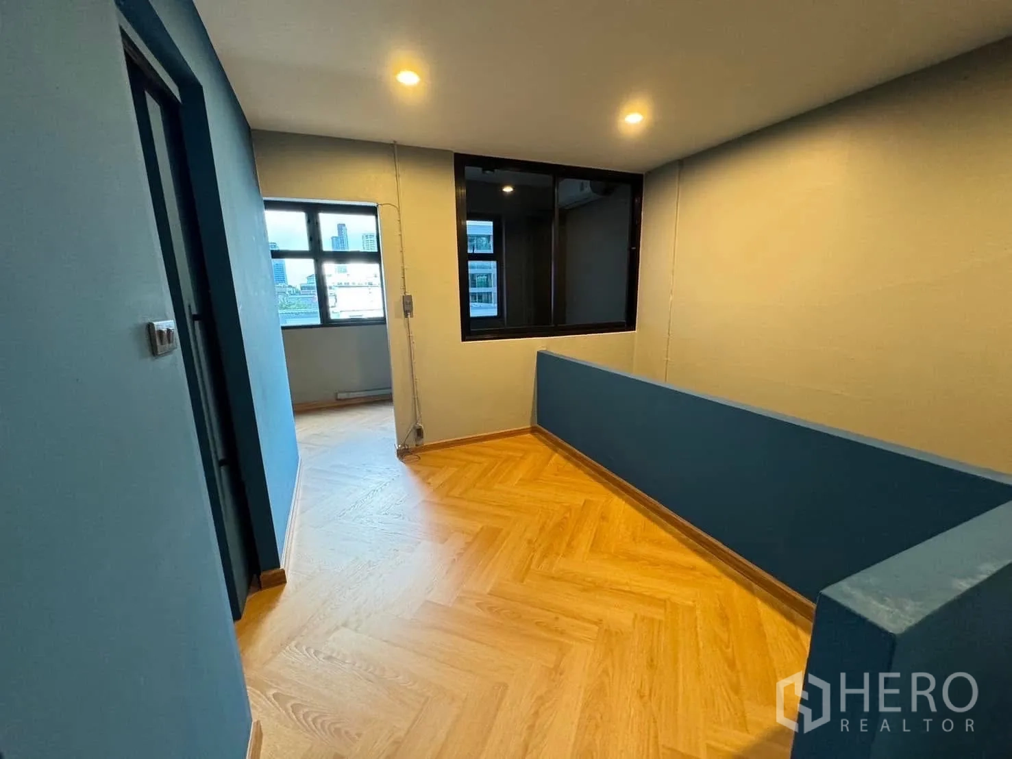 โฮมออฟฟิศ for rent in Watthana, Bangkok - โถงทางเดินชั้นบน พื้นไม้ลายก้างปลา และผนังกั้นกระจกภายใน