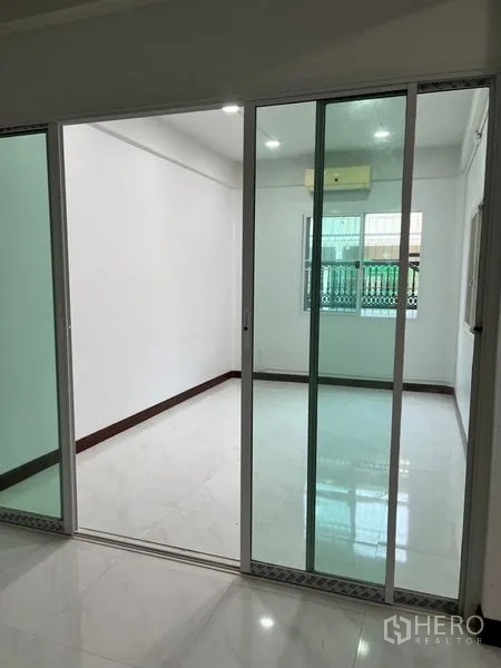 Townhouse for rent in Din Daeng, Bangkok - Covered front terrace or parking bay with patterned tiles and sliding glass doors.