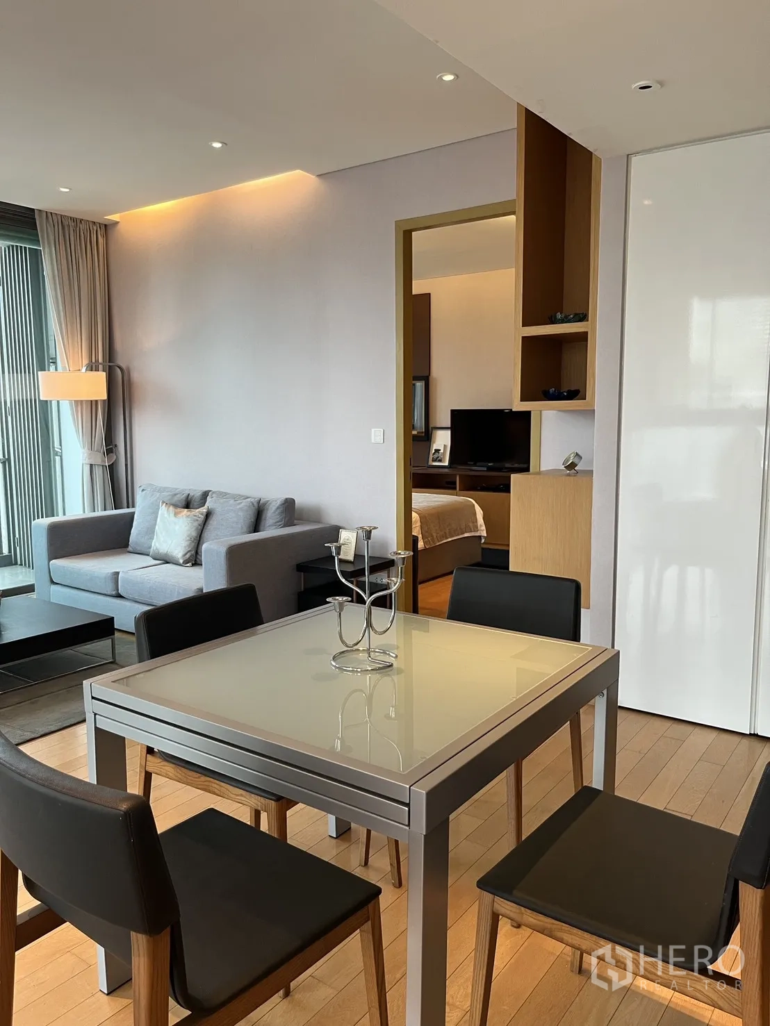 Condominium for rent in Watthana, Bangkok - Dining area leading to a lounge and bedroom entry, with soft cove lighting.