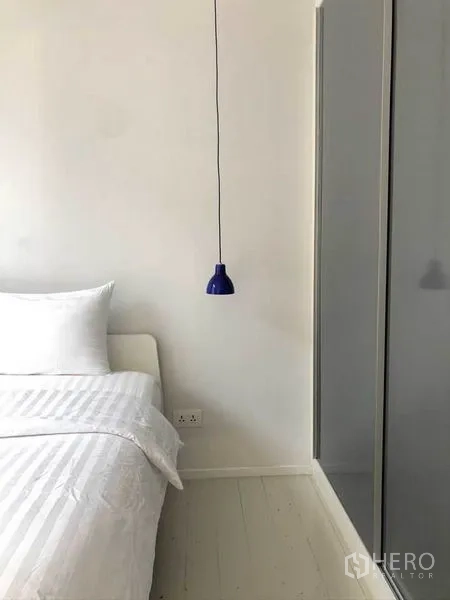 公寓 出售在Watthana, Bangkok - 温馨卧室，白色床品、蓝色吊灯与衣柜。