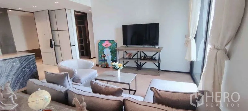 公寓 出租在Watthana, Bangkok - 舒适客厅，转角沙发、单椅与电视柜，采光充足。