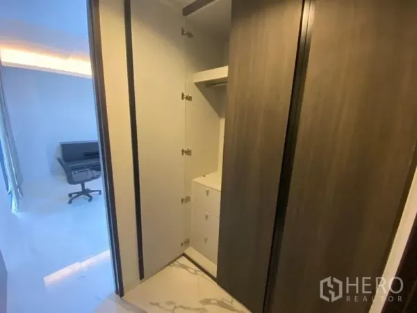 办公空间 出租在Phaya Thai, Bangkok - 内置衣柜带开放式层架与抽屉，旁边为明亮的工作区。