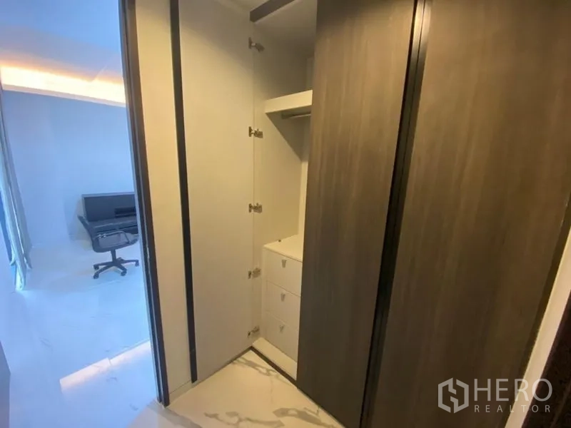 办公空间 出租在Phaya Thai, Bangkok - 内置衣柜带开放式层架与抽屉，旁边为明亮的工作区。