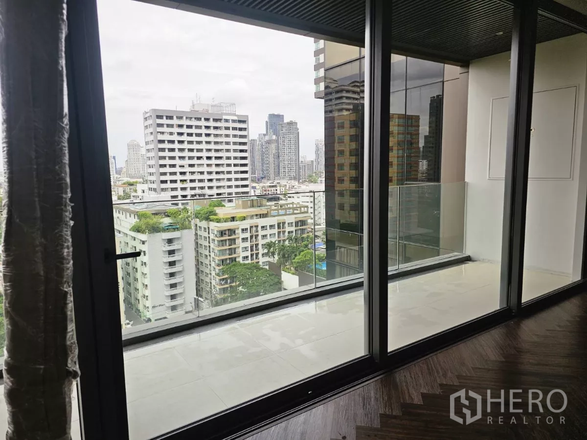 公寓 出租在Watthana, Bangkok - 宽大阳台与落地推拉门，眺望素坤逸城市景观。
