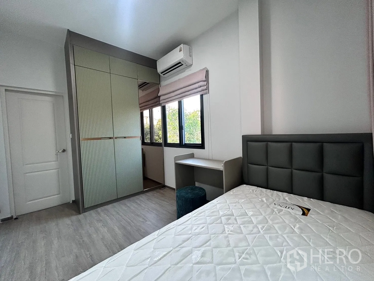 Semi-detached House for rent in Bang Phli, Samut Prakan - Bright bedroom with padded headboard, built-in wardrobe, desk, and windows with blinds.