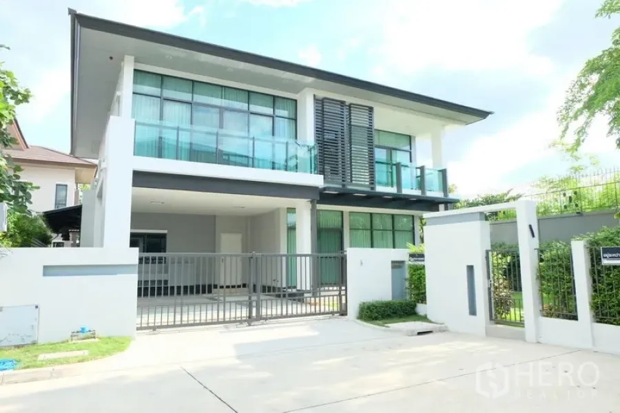 独立式住宅 出租在Prawet, Bangkok - 现代两层独栋别墅外观，落地窗与阳台，带前院电动门车位