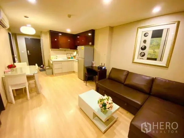 公寓 出租在Ratchathewi, Bangkok - 开放式起居区，配沙发、餐桌及带冰箱的紧凑厨房。