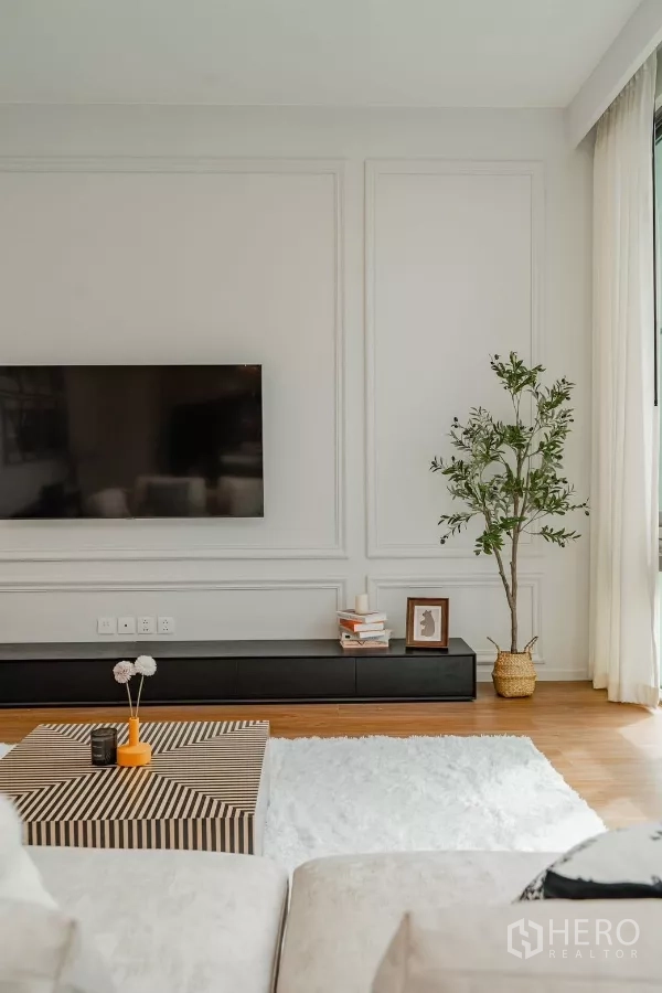 Detached House for rent in Saphan Sung, Bangkok - TV feature wall with low console, indoor plant and striped coffee table.