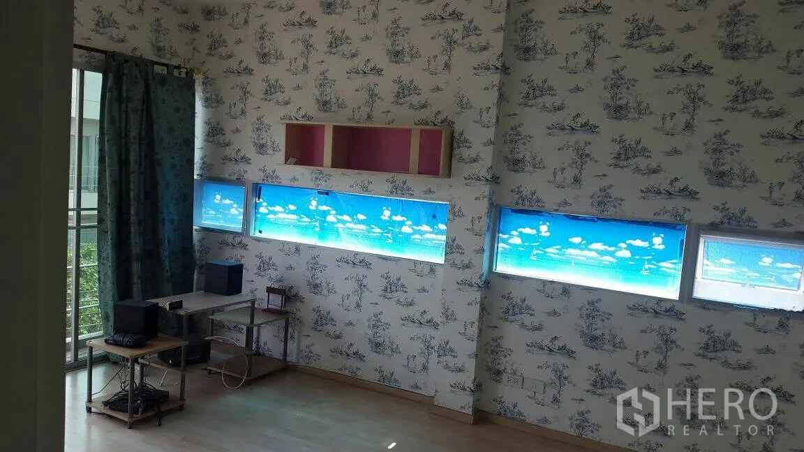 Townhouse for rent in Suan Luang, Bangkok - Bright multipurpose room with patterned wallpaper and slim horizontal windows.