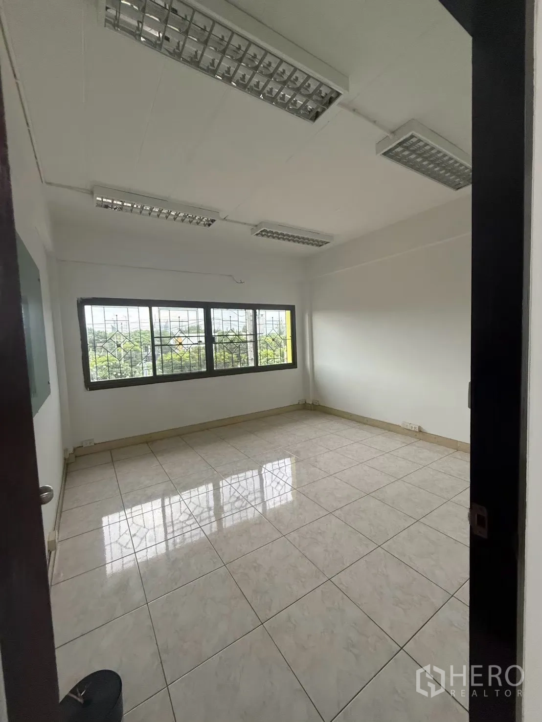 Shophouse for rent in Pak Kret, Nonthaburi - Office room with large window and ceiling light panels.