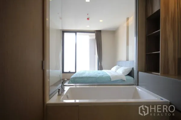 公寓 出租在Watthana, Bangkok - 浴缸靠玻璃隔断，可眺望卧室与城市光景