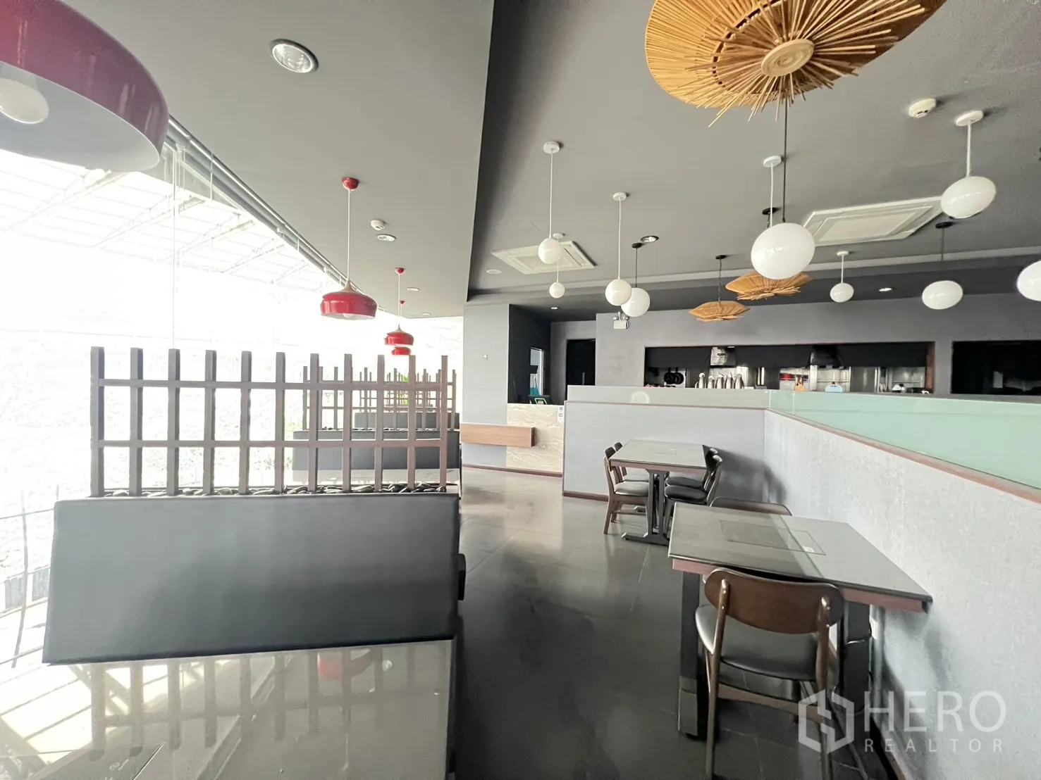 零售空间 for rent in Watthana, Bangkok - 素坤逸曼谷现代商铺内景，整面落地玻璃、吊灯与餐桌，适合餐饮经营。