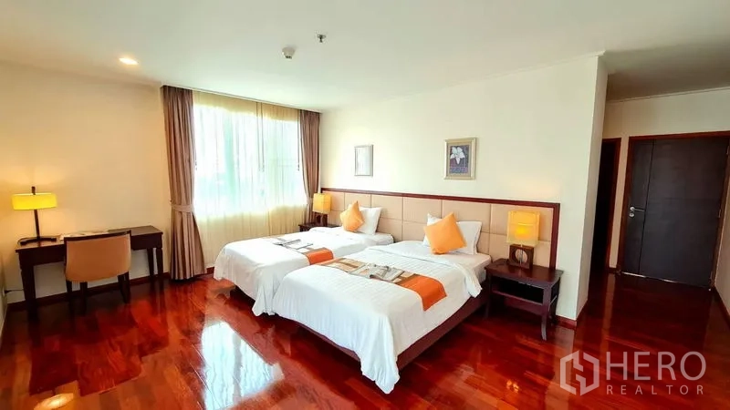 Apartment for rent in Khlong Toei, Bangkok - Second master bedroom with king bed, work desk and warm lighting.