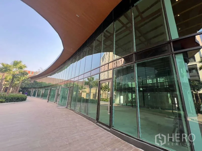 Retail Space for rent in Watthana, Bangkok - Curved glass-front retail arcade with floor-to-ceiling windows and entry doors.