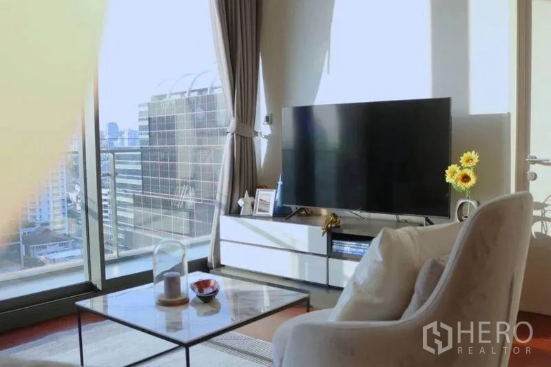 公寓 出租在Watthana, Bangkok - 电视角落旁是落地窗与阳台，可观曼谷天际线。