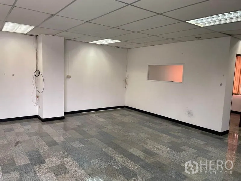 Office Space for rent in Khlong Toei, Bangkok - Spacious empty room with white walls, grid ceiling and cabling ready for fit‑out.