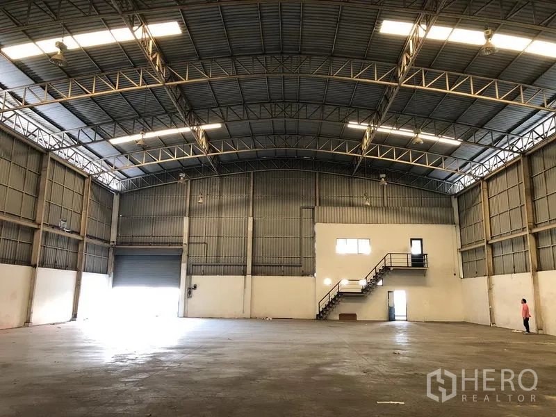 Factory for rent in Wang Noi, Phra Nakhon Si Ayutthaya - Warehouse hall showing roller shutter loading door, concrete floor, and ample clear span.