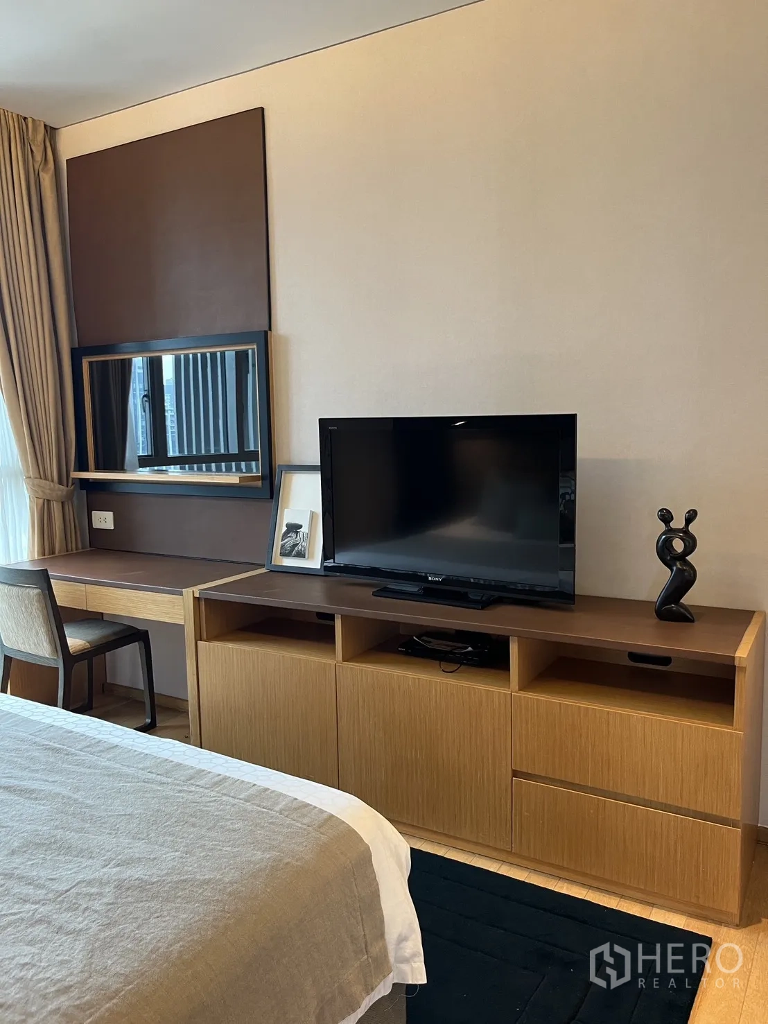 Condominium for rent in Watthana, Bangkok - Bedroom corner with TV console, study desk, and window drapes.