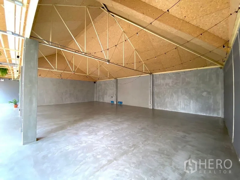 Retail Space for rent in Watthana, Bangkok - Open-plan retail unit with high pitched ceiling, exposed beams, and concrete flooring.