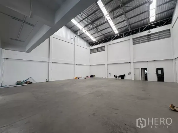 Factory for rent in Phra Samut Chedi, Samut Prakan - High-bay factory interior with skylights and smooth concrete floor.
