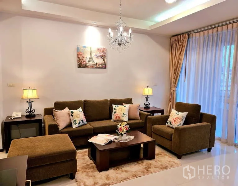 Apartment for rent - Cozy living room with brown sofa, armchair, chandelier and large sheer window.