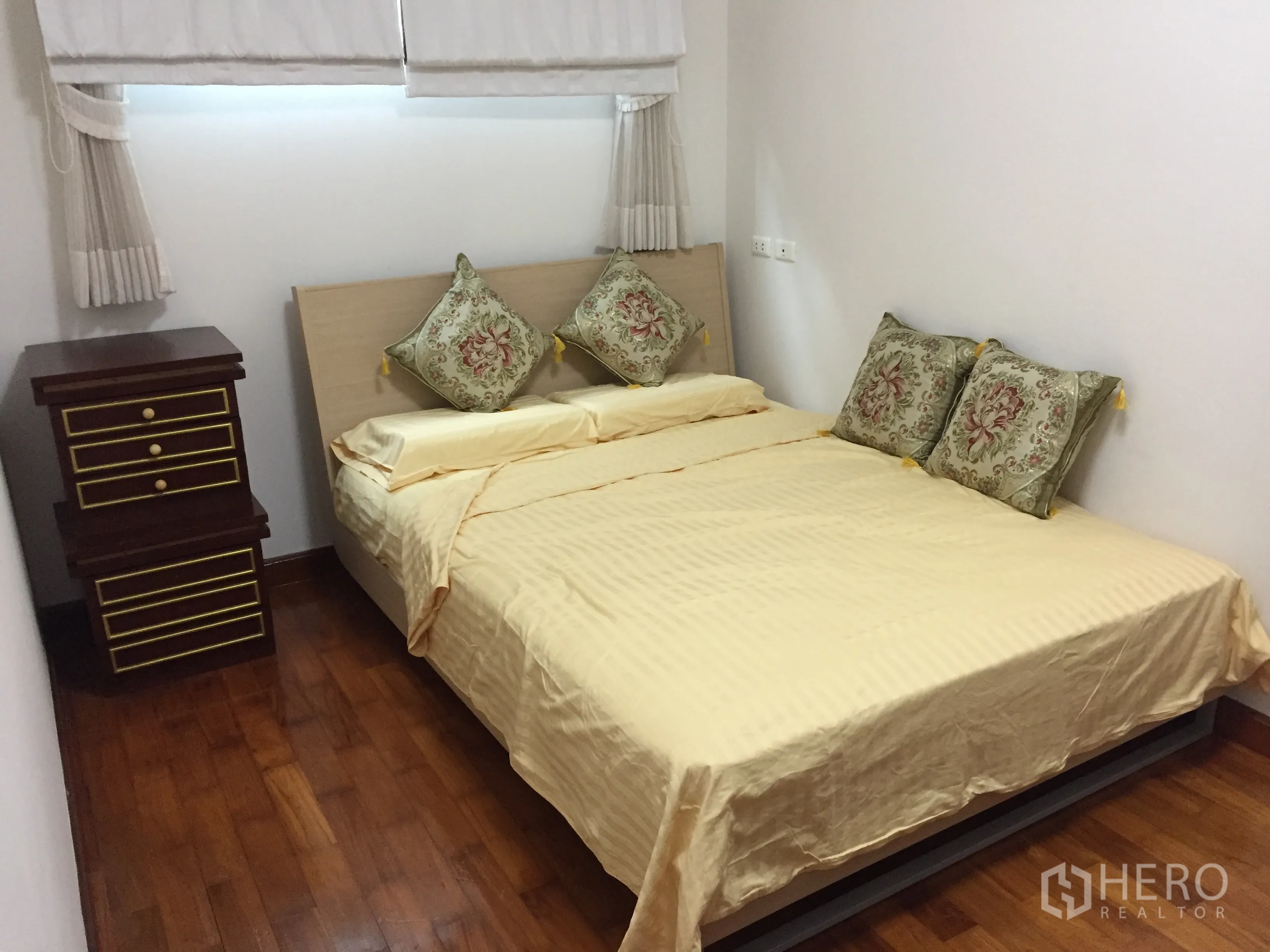 Condominium for rent in Watthana, Bangkok - Cozy bedroom with double bed, decorative pillows and bedside drawers on wood flooring.
