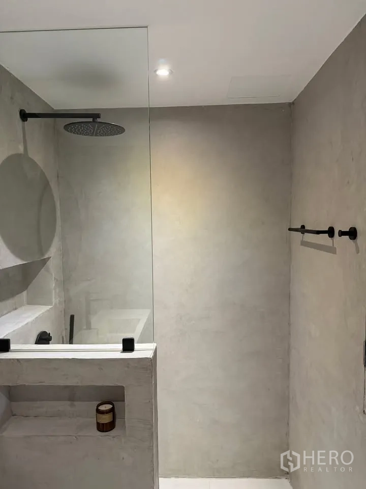 公寓 for rent in Watthana, Bangkok - 步入式淋浴间，水泥质感墙面、顶喷花洒与壁龛。